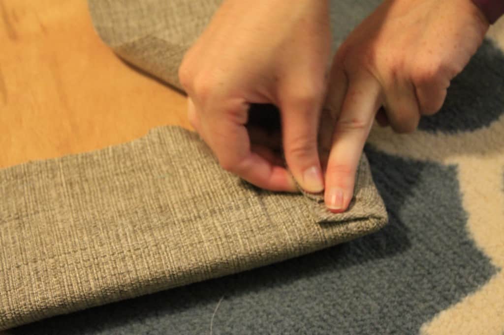 A photo of the upholstery fabric being carefully folded at the corners like gift wrapping. 