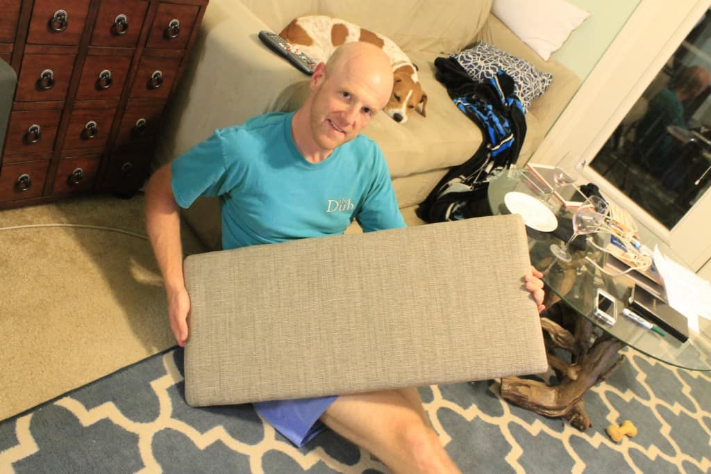 A photo of a man holding the finished upholstered seat. 