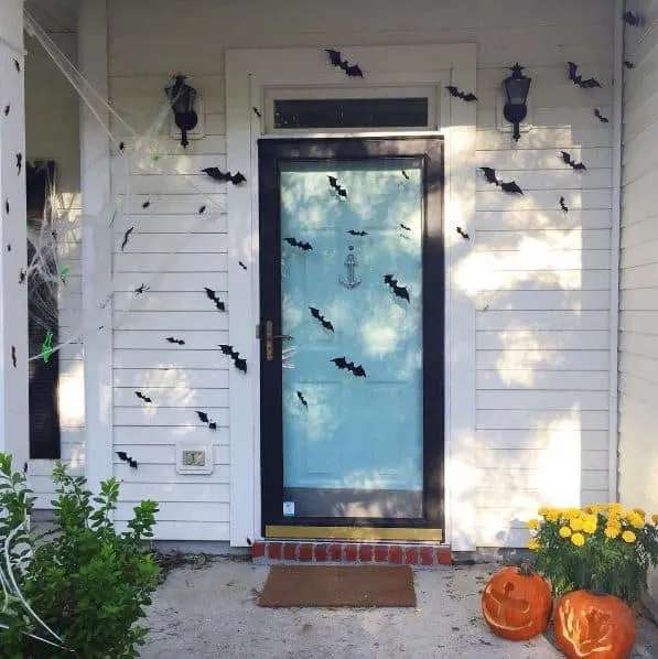 Halloween door decorated with 3D bats and spiderwebs - Charleston Crafted