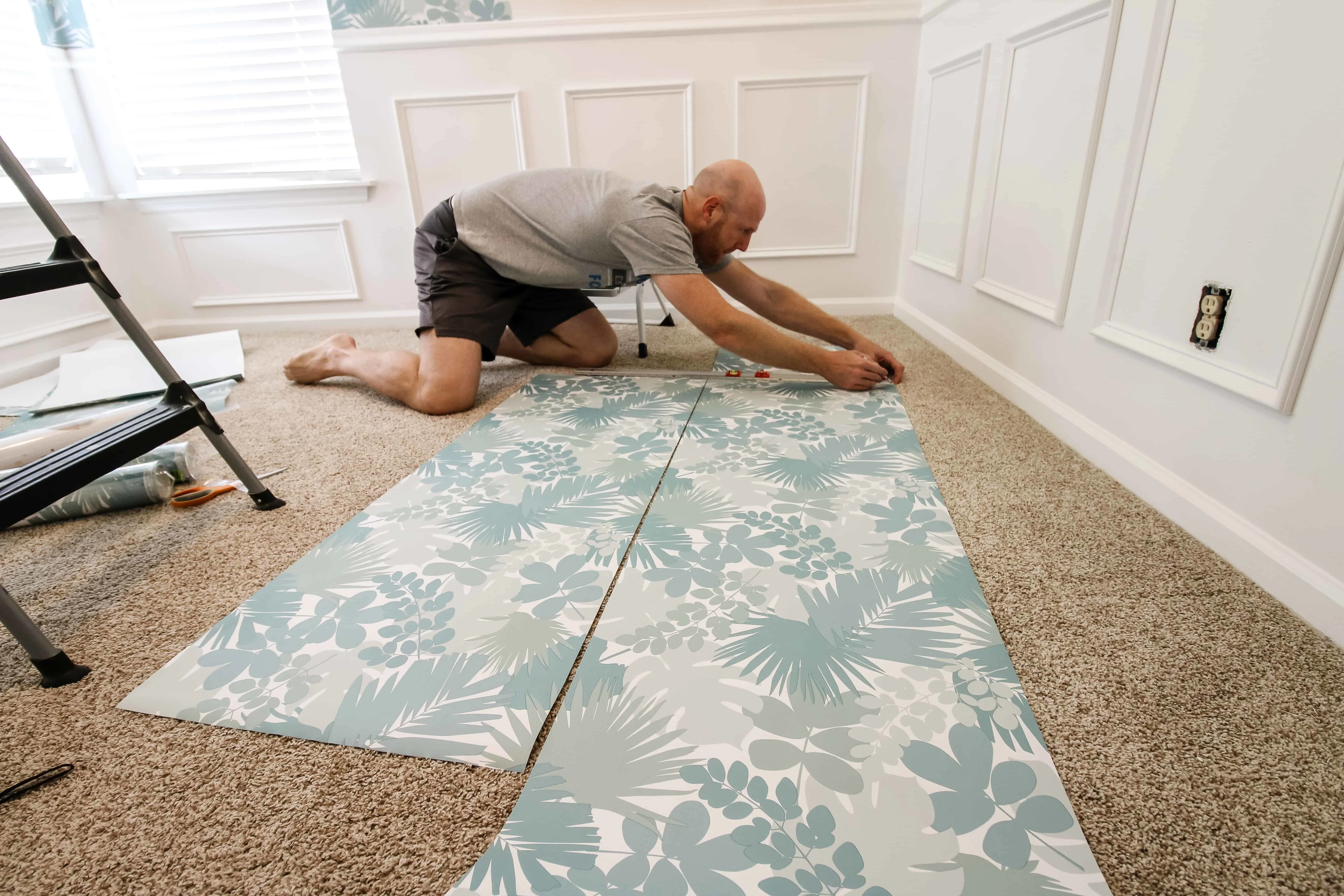 measure and cut two pieces of peel and stick wall paper at a time for easiest cutting 