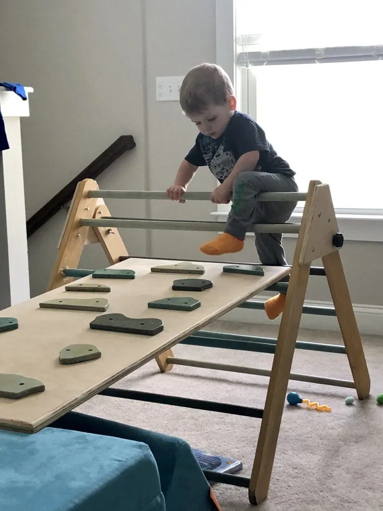 toddler climbing a homemade pikler triangle