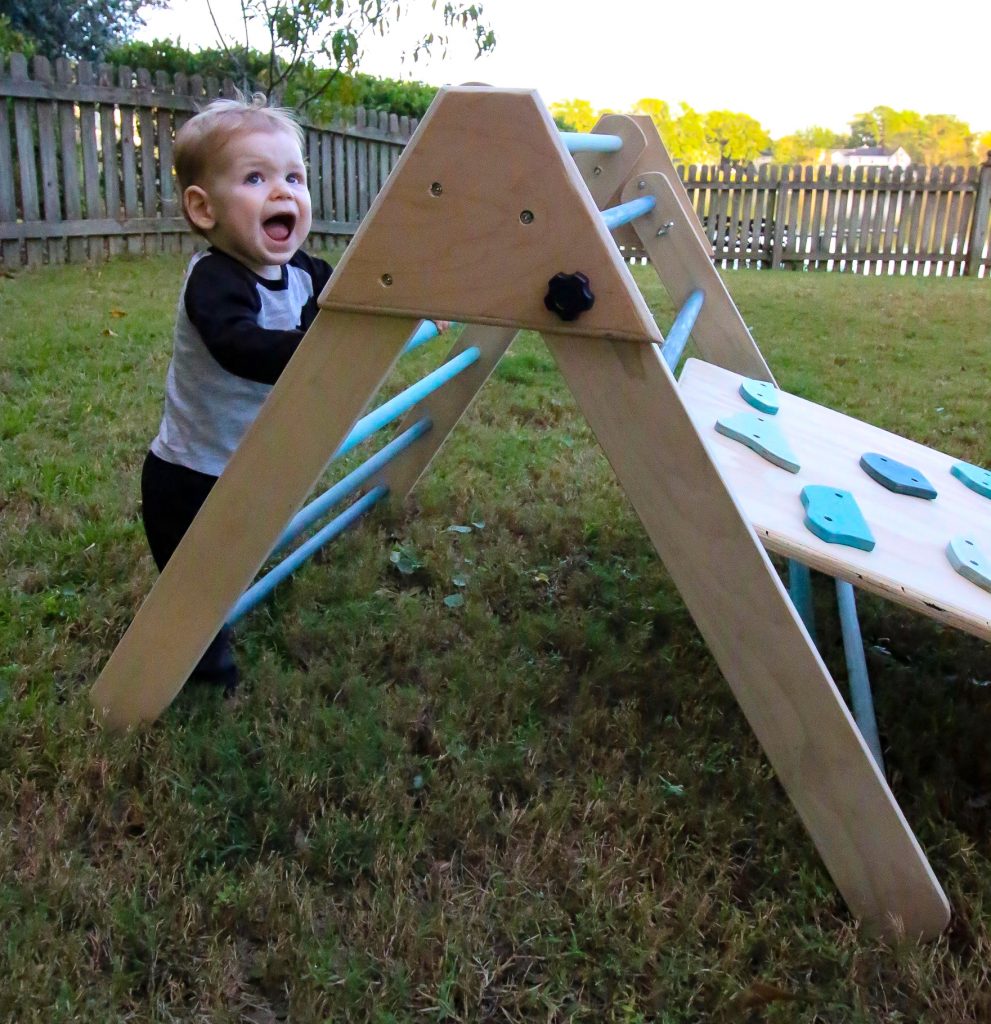 Kid climbing Pikler Triangle