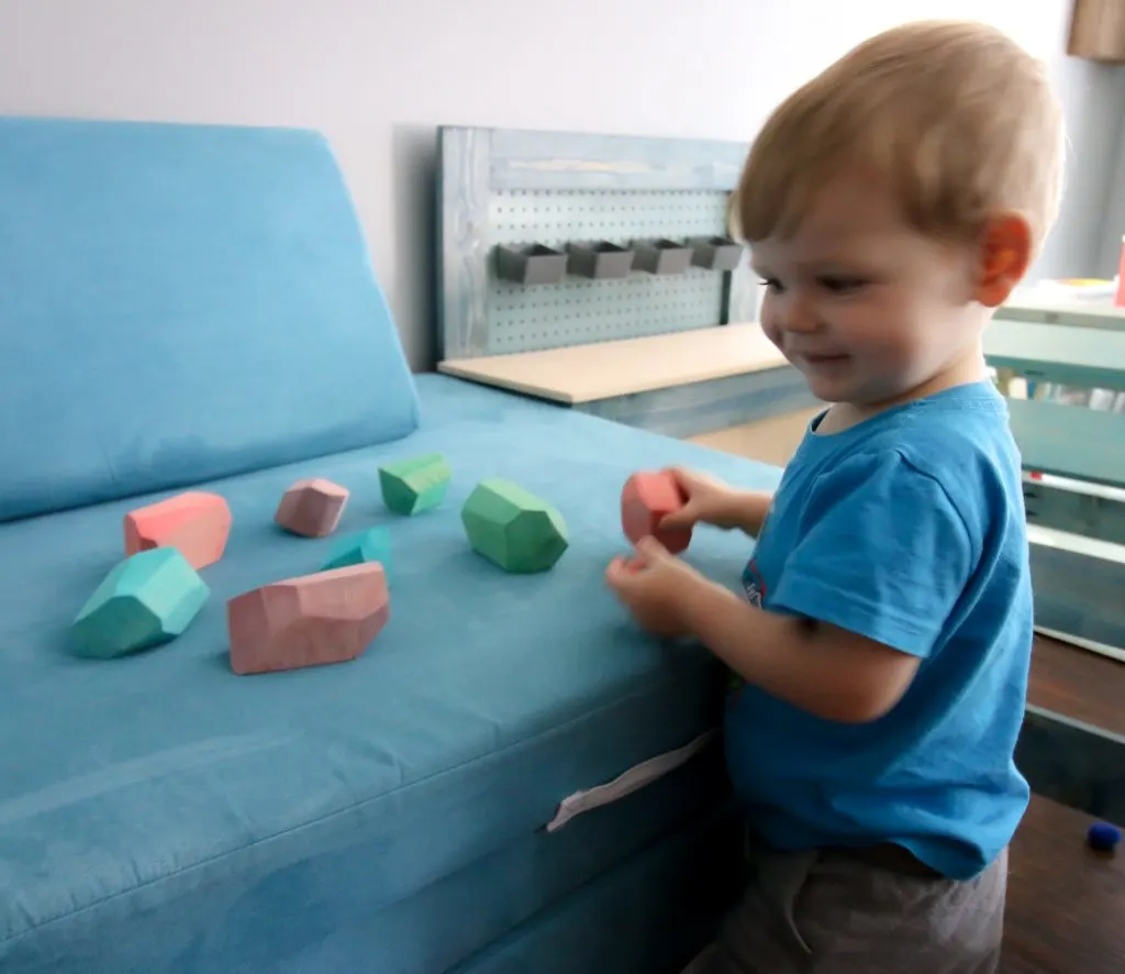 Toddler playing with wooden balancing stones