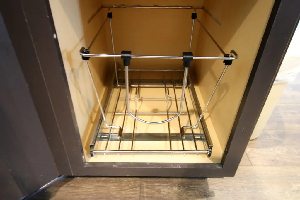 Attaching pull out trash can system to cabinet