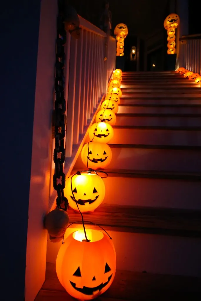pumpkin pails with twinkle lights on stairs halloween