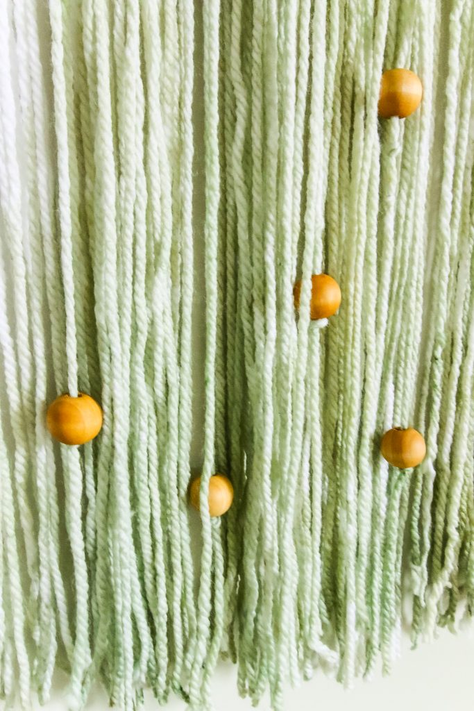 wooden beads on a yarn wall hanging