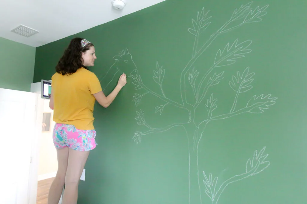 sketching a mural on the wall with chalk