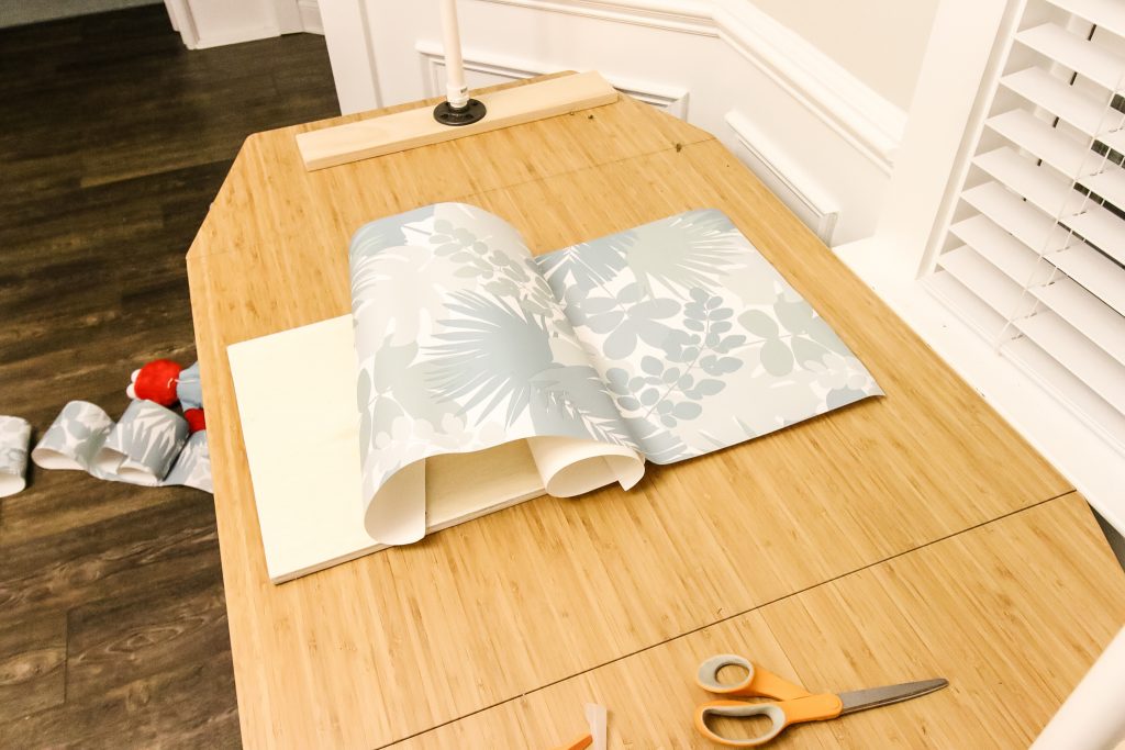 Applying wallpaper to shelf sides