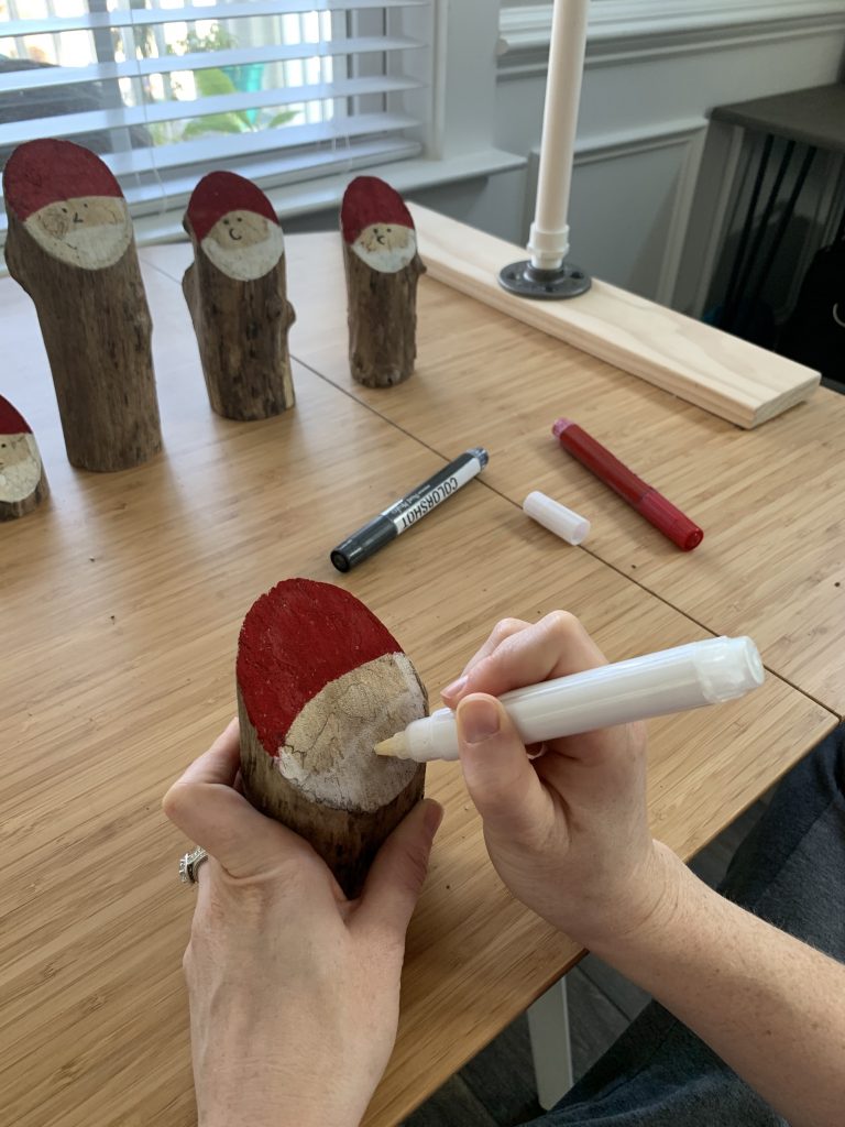 painting a santa beard on a rustic log