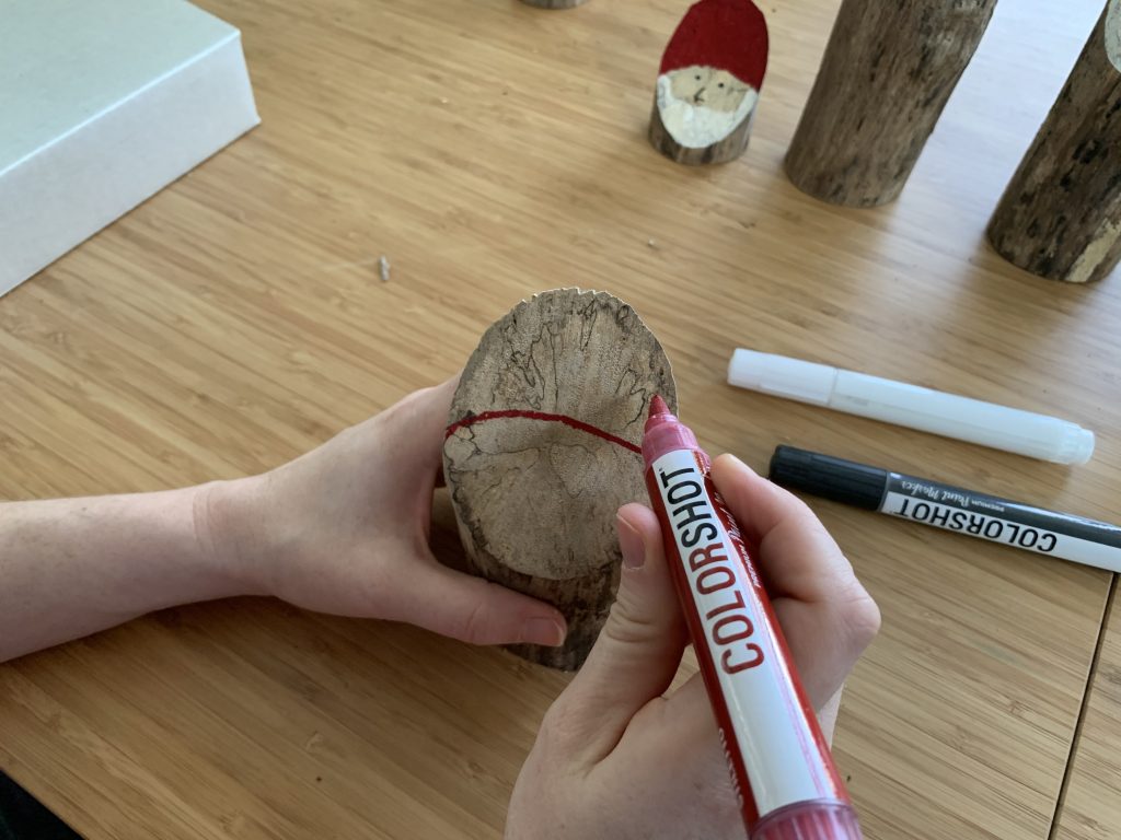 painting santa hat on log