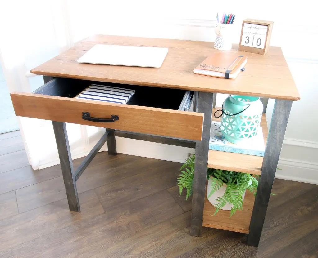 Drawer open on writing desk with supplies
