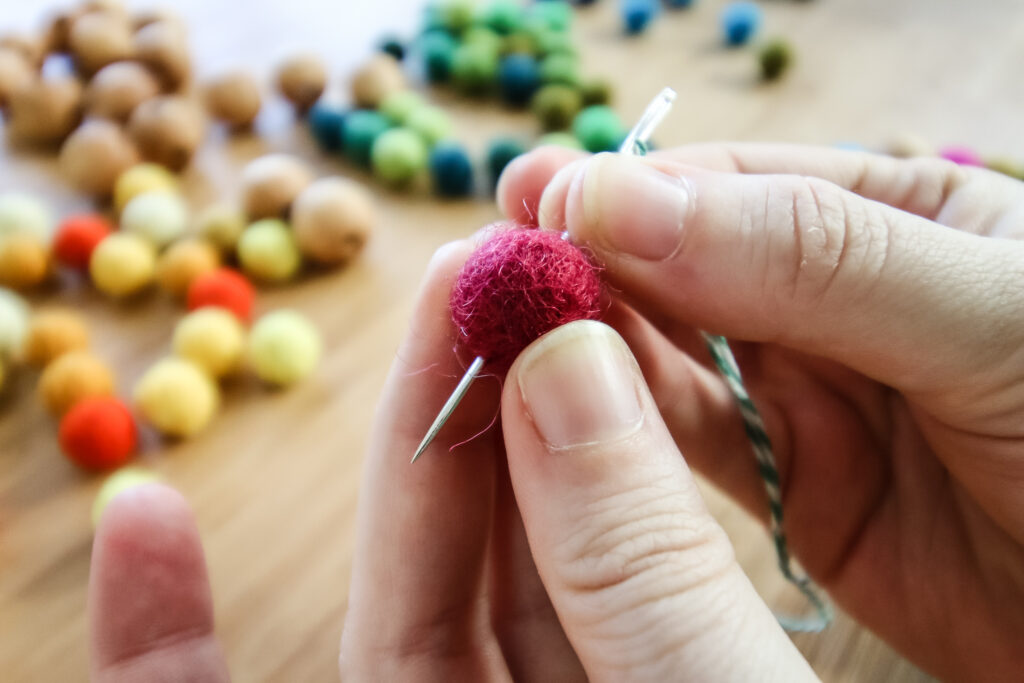 thread needle through felt ball pom pom