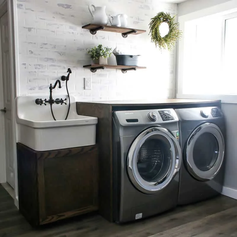 https://www.charlestoncrafted.com/wp-content/uploads/2021/02/Modern-farmhouse-luandry-room-with-farmhouse-utility-sink-and-folding-table.jpg.webp