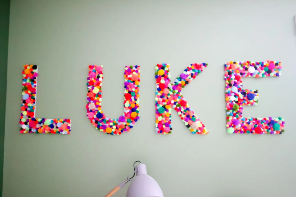 DIY pom pom letters spelling LUKE
