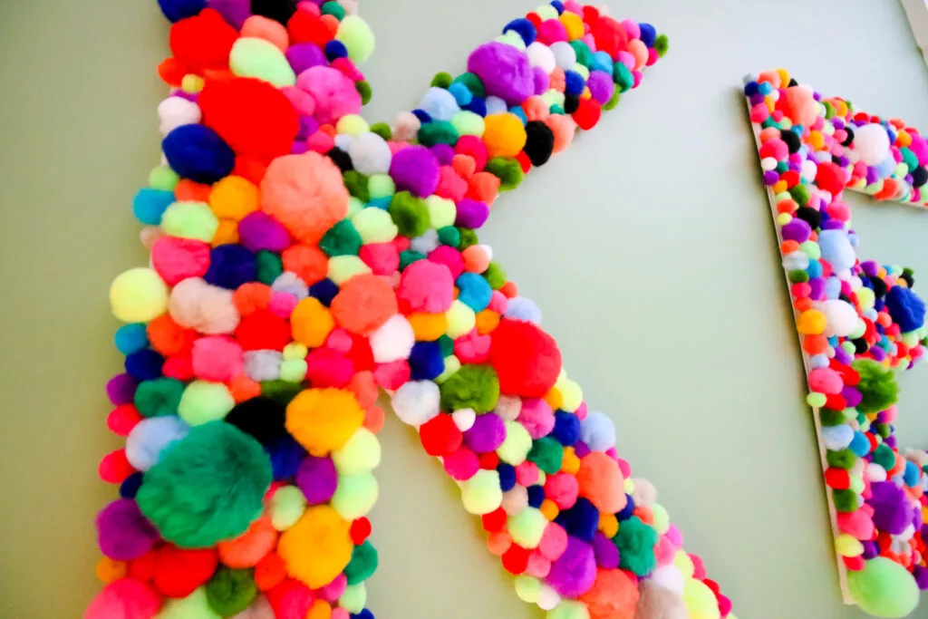 Close up of DIY wall hanging pom pom letters