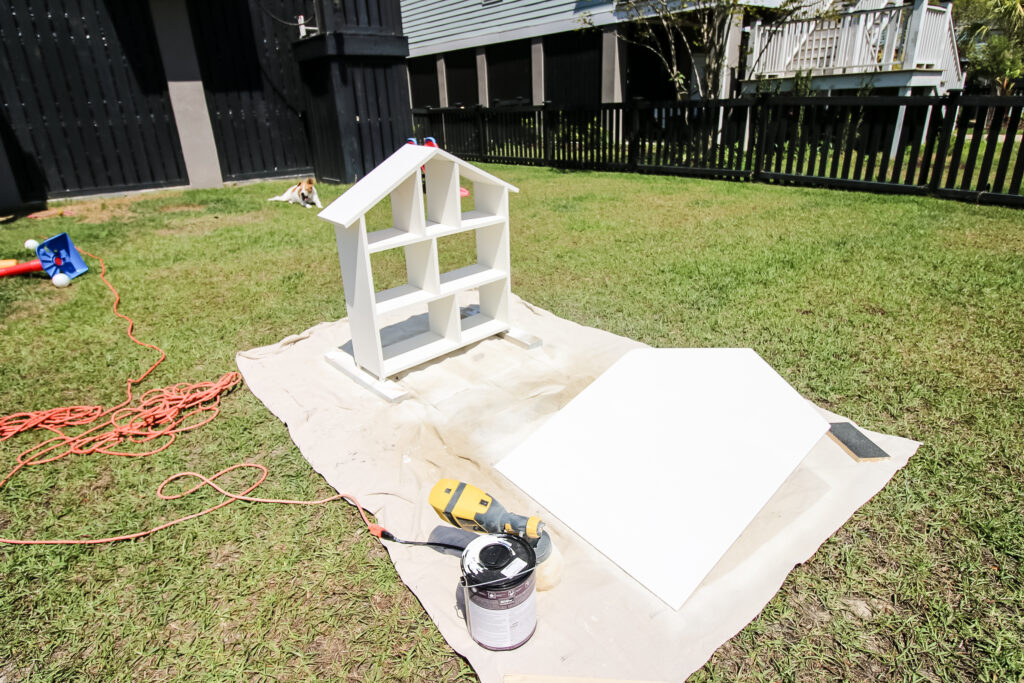 Using paint sprayer to paint dollhouse bookshelf