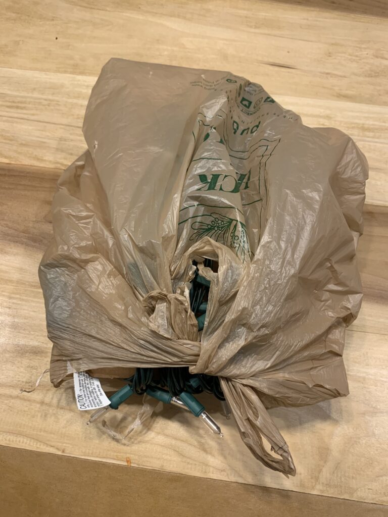 christmas lights wrapped around cardboard in a bag