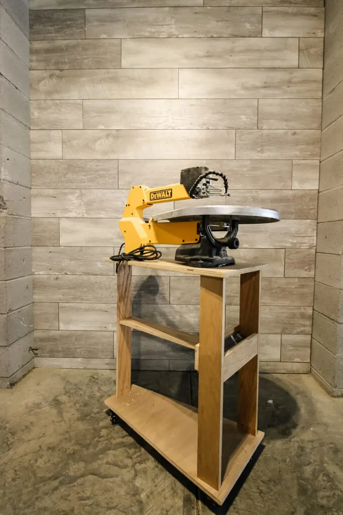 Photo of scroll saw stand in front of feature wall
