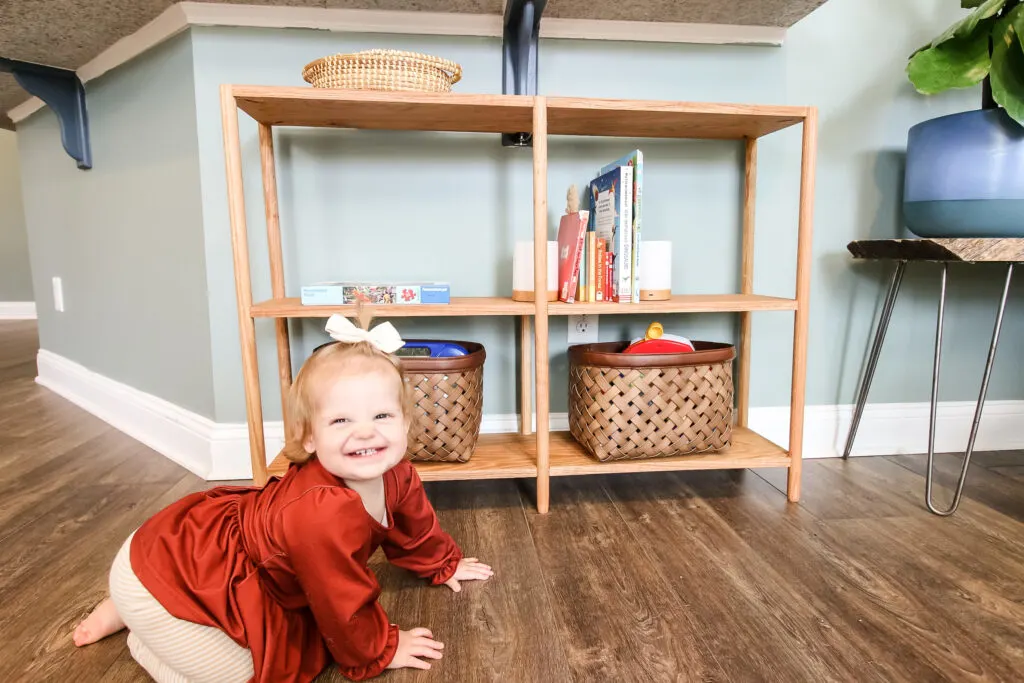 Toddler with DIY dowel rod bookshelf