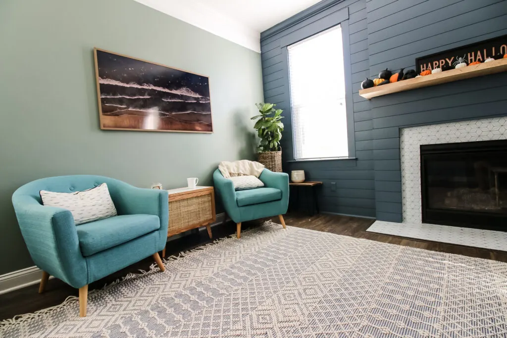 Wide view of living room with side table and fireplace