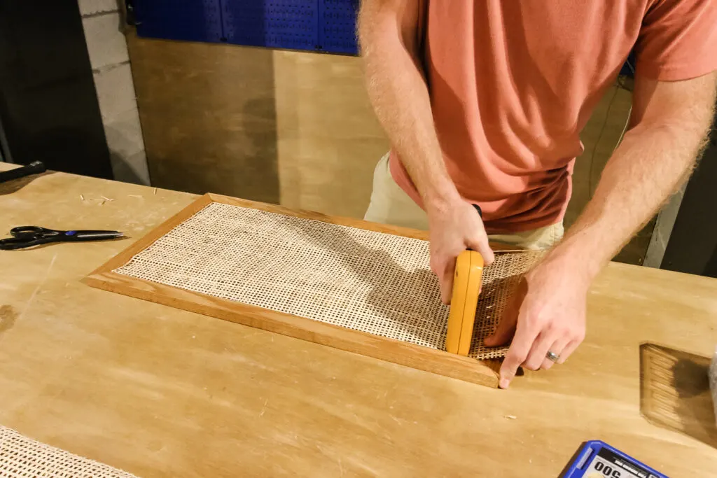 Stapling rattan cane webbing into the door of the side table