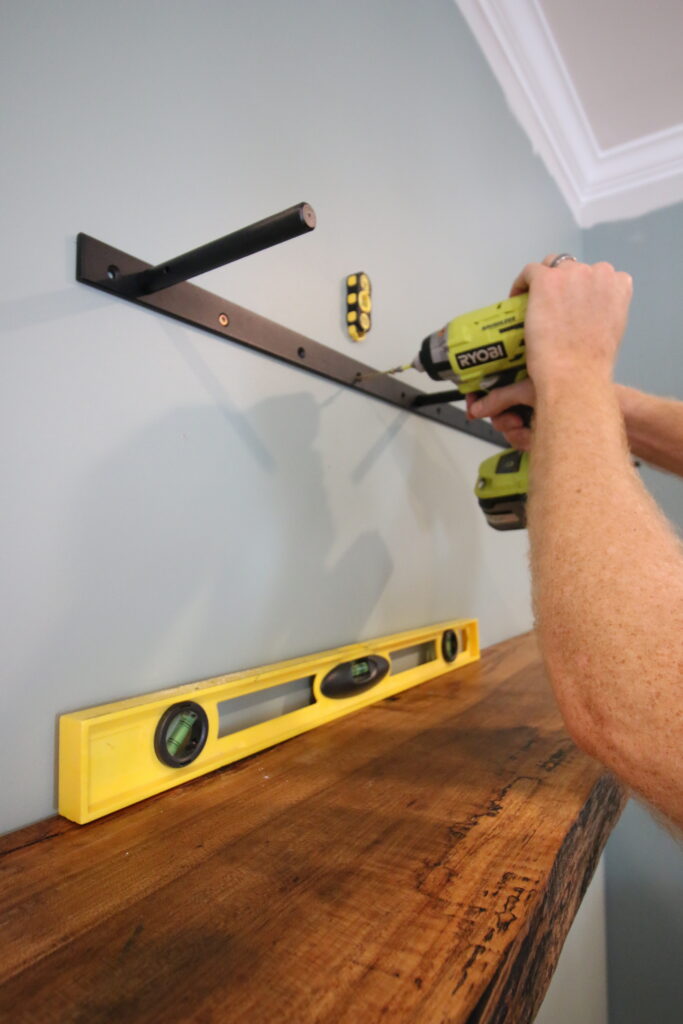 Attaching floating shelf bracket to wall