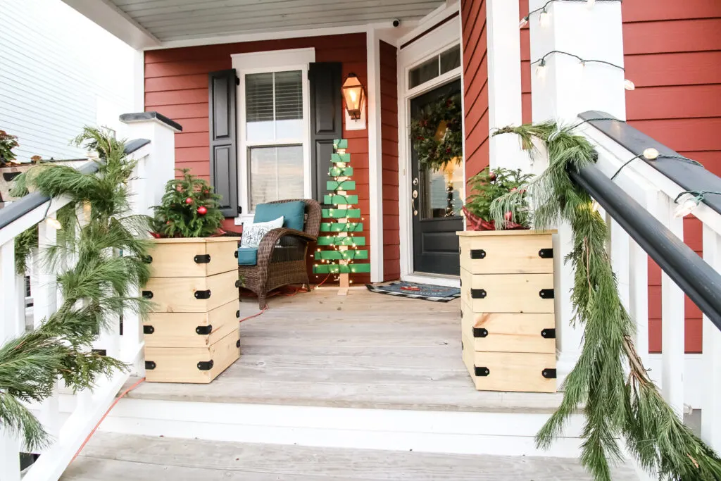 front porch for christmas with wood tree and tree boxes
