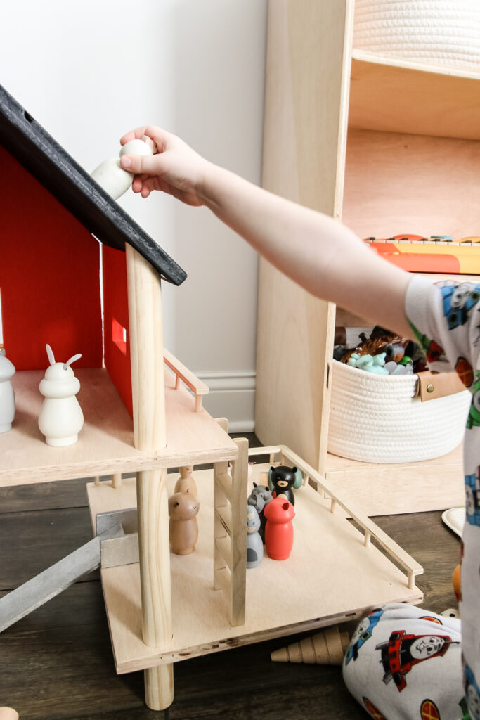 Playing with wooden toy treehouse