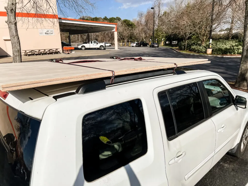 Plywood strapped to roof of car at Home Depot