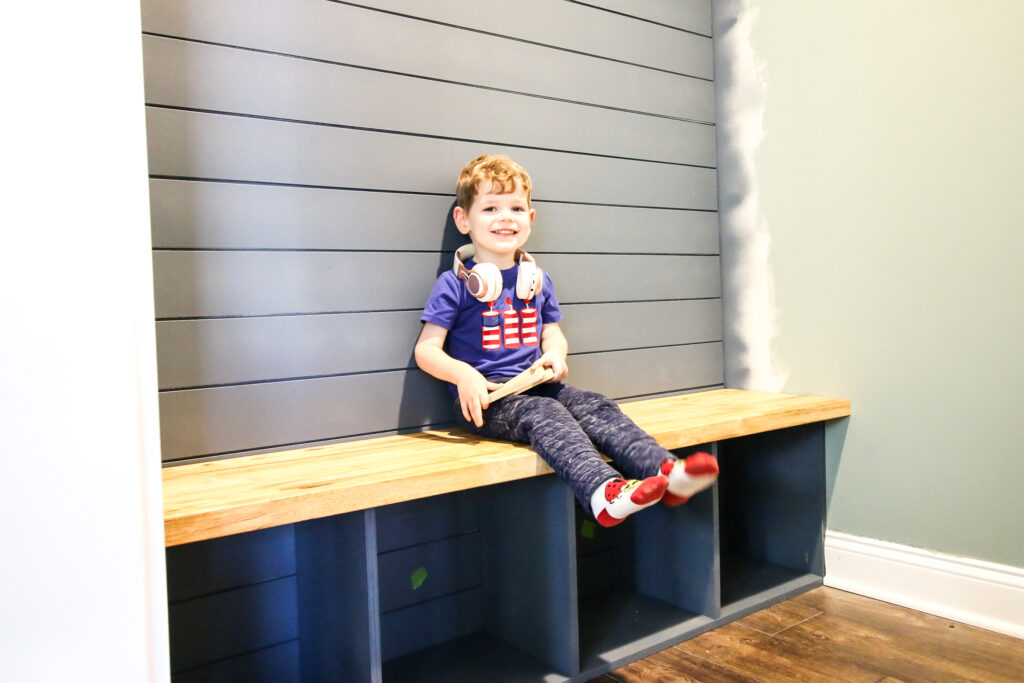 Luke sitting on mudroom bench