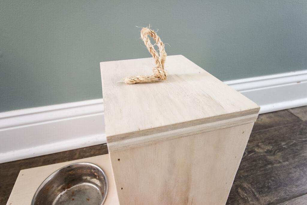 Top of cat food dispenser with rope pull
