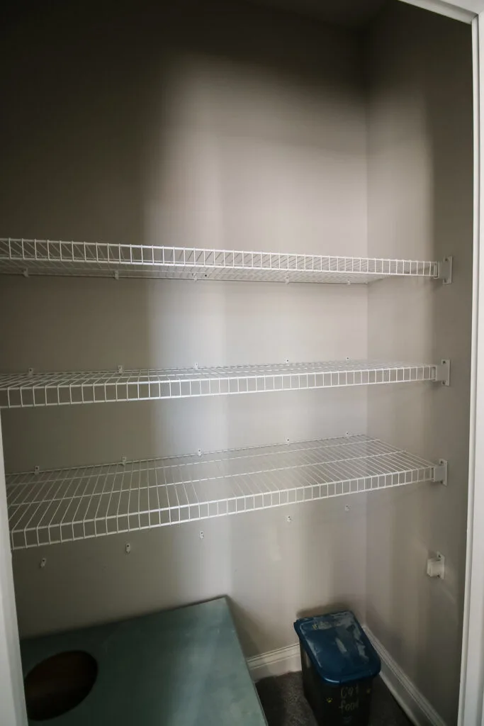 Wire shelving in linen closet before renovation