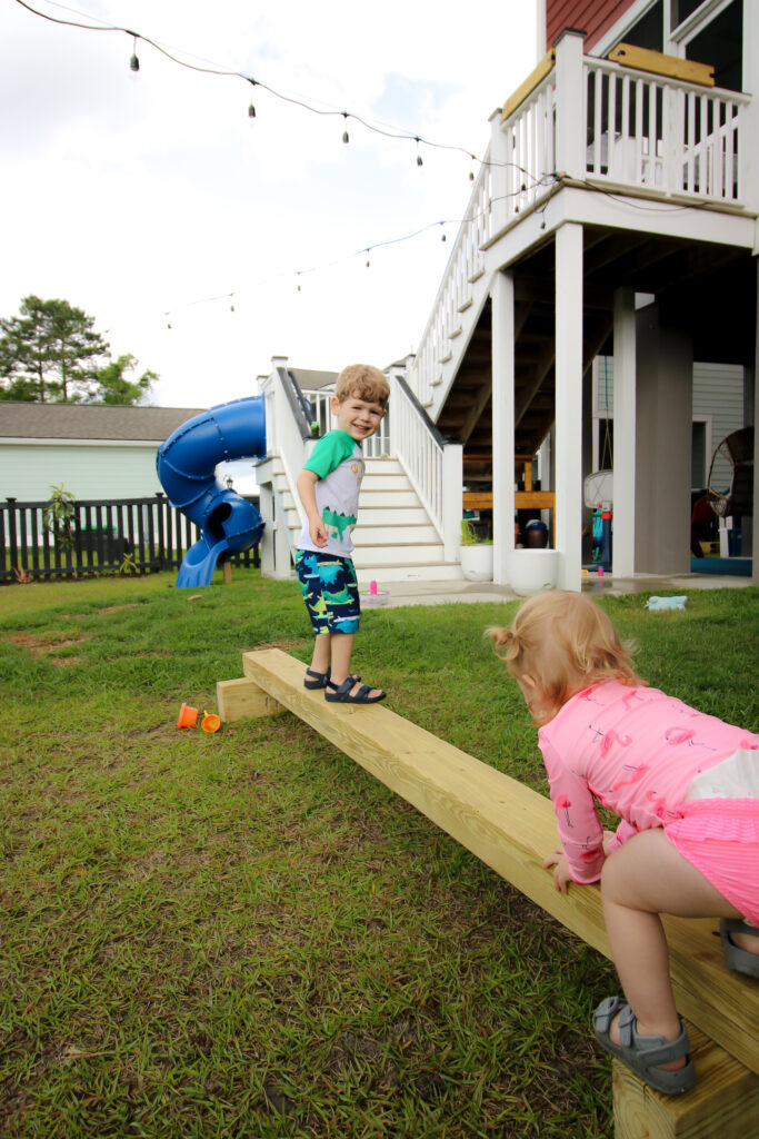 Toddler climbing onto balance beam