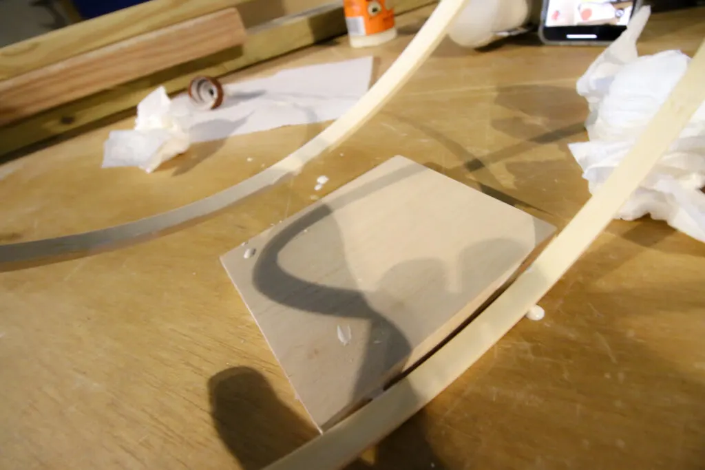 applying glue to the pieces of the wooden plant holder