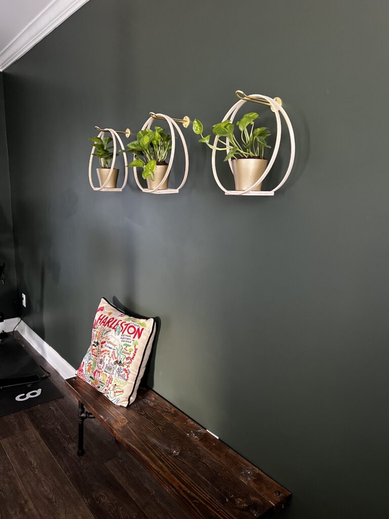 three wooden hoop hangers hanging on a wall above a bench