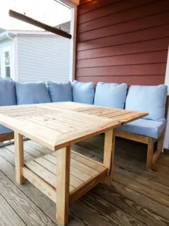 Tall view of DIY square outdoor dining table with string lights and couch