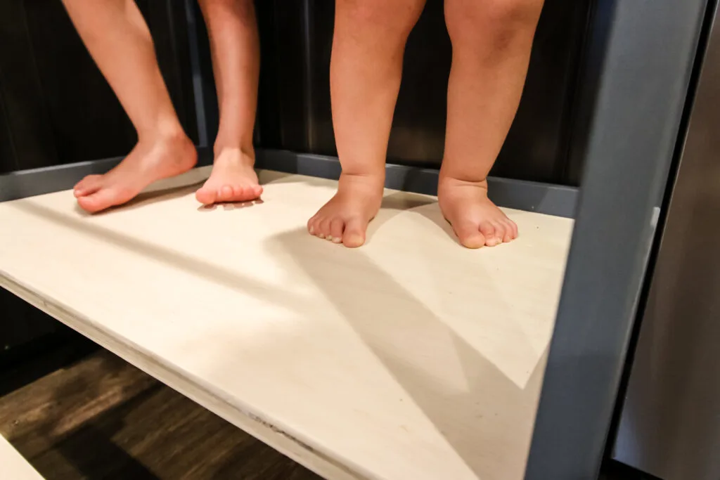 Toddler feet on platform of learning tower