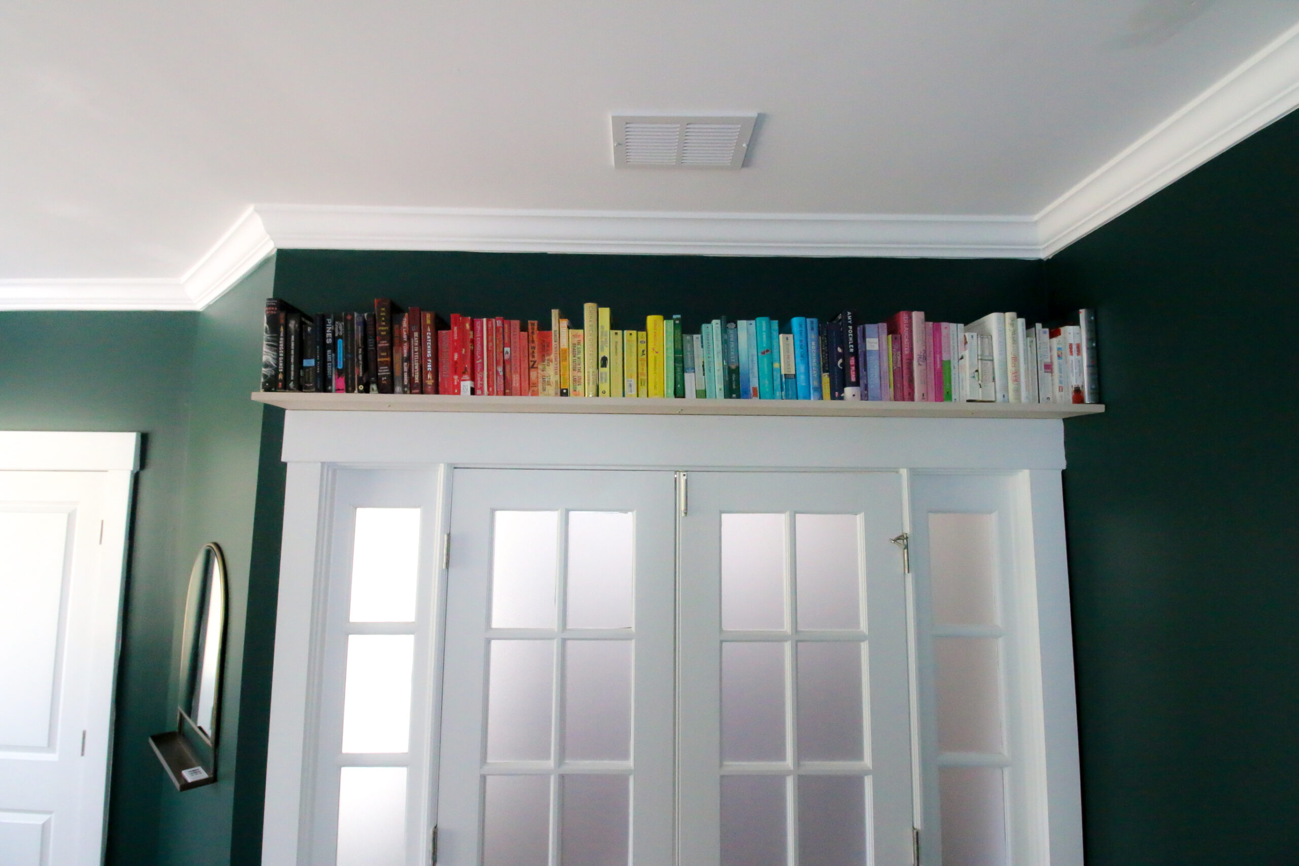 shelf of rainbow books over the door