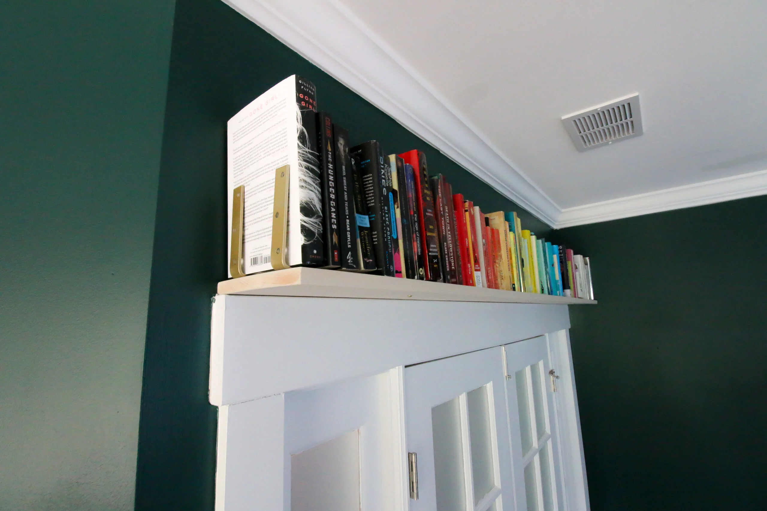 L bracket holding books on bookshelf