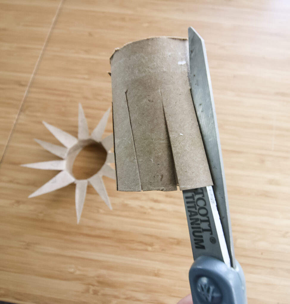 cutting slits into a toilet paper roll