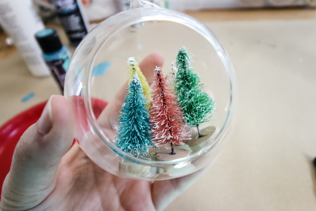 bottle brush trees glued inside of clear glass ornament ball