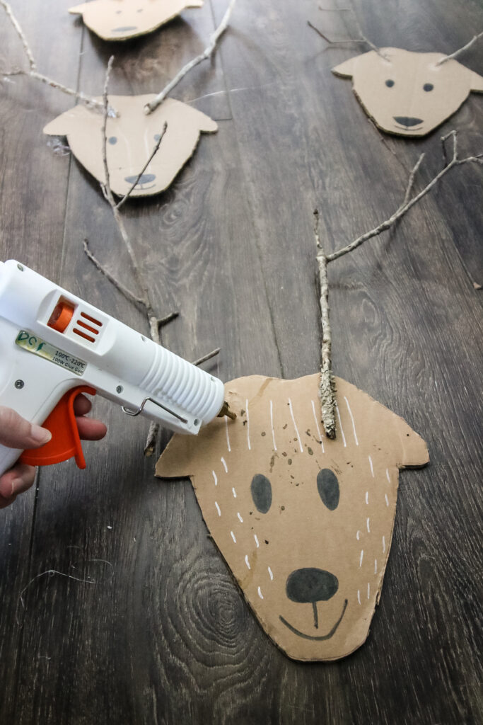 hot gluing antlers to cardboard reindeer