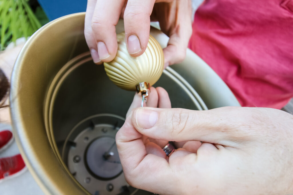 Tying gold ornament onto twine