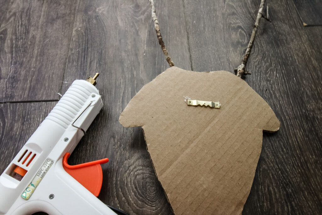 hot gluing hooks to the back of cardboard reindeer