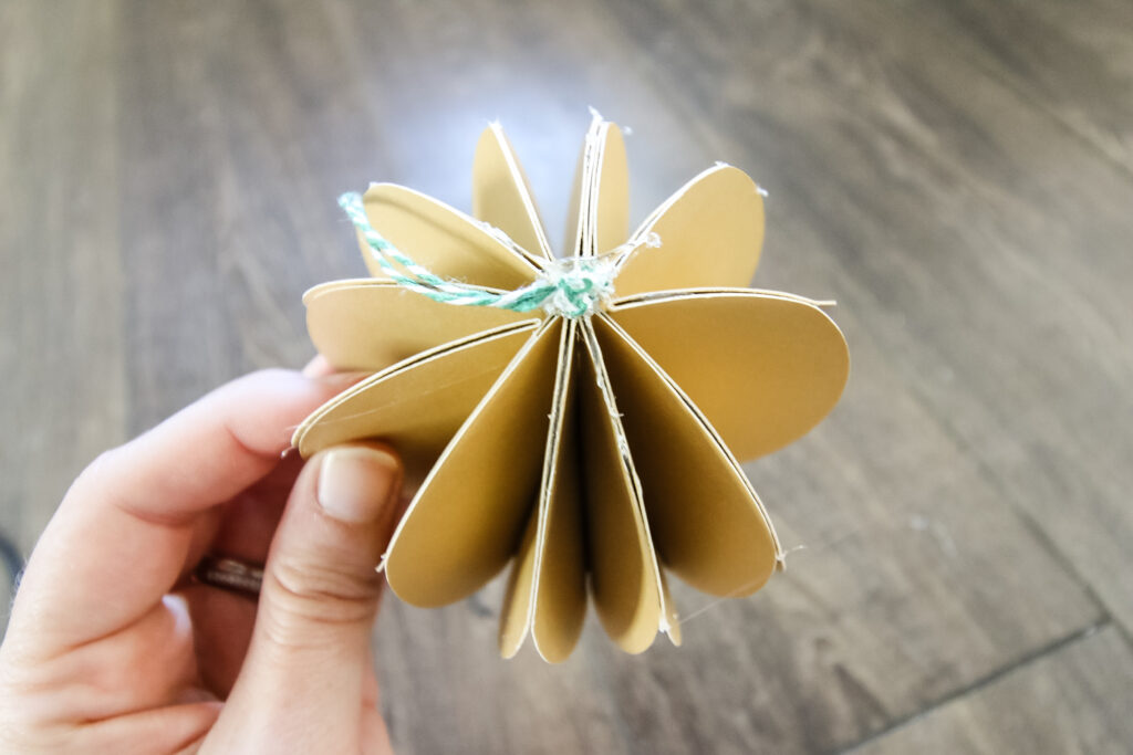 string on top of paper ornament ball