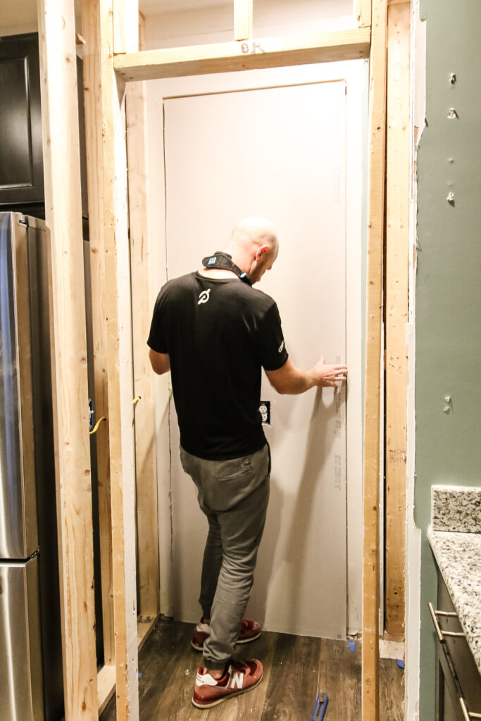 Putting up drywall to fill doorway