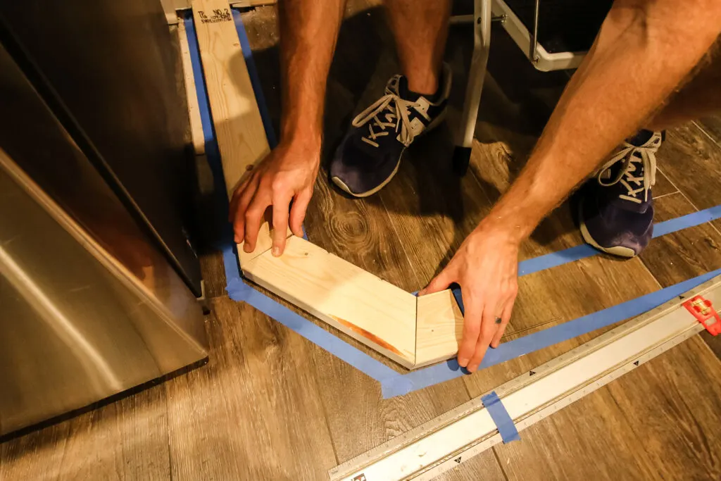 Marking layout of new pantry on the ground with painter's tape