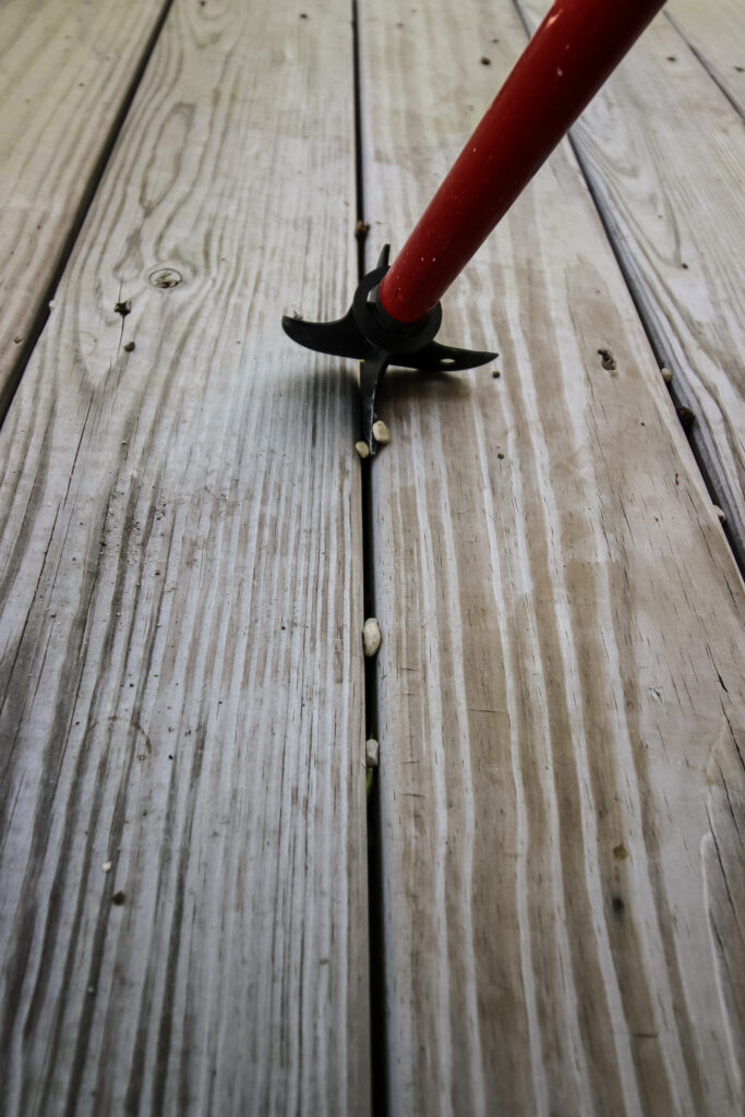 Cleaning debris from between deck boards with Zenith Crack and Crevice Cleaner