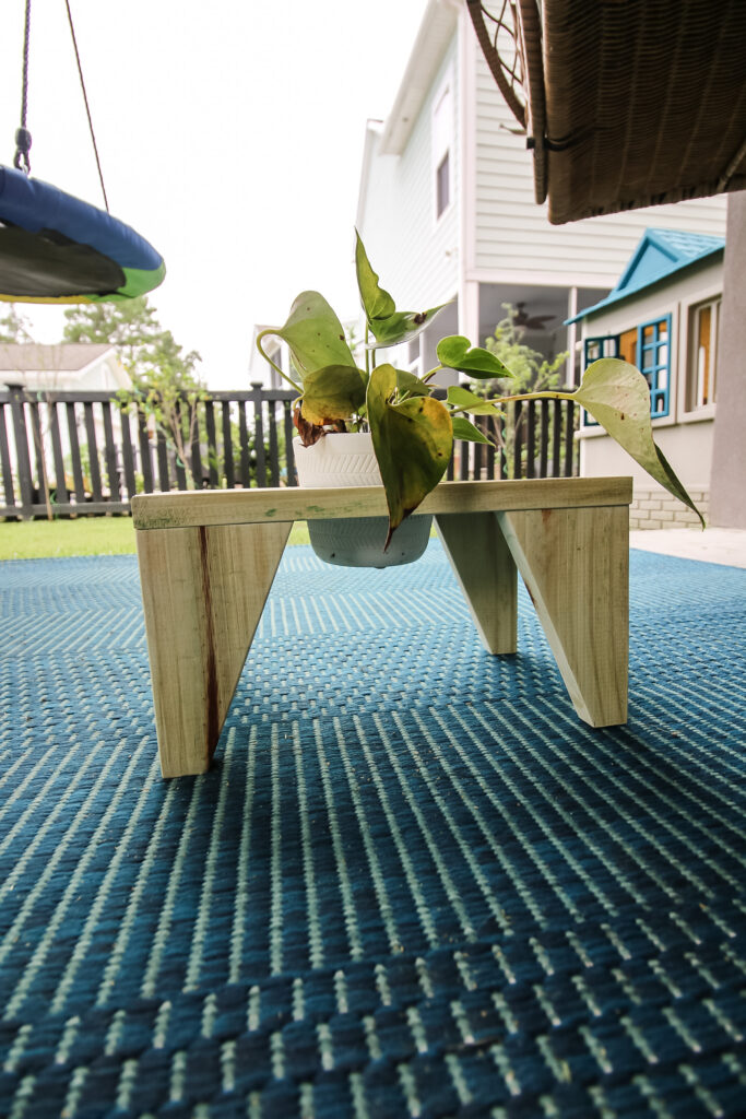 Plant riser with tapered legs and hole for pot