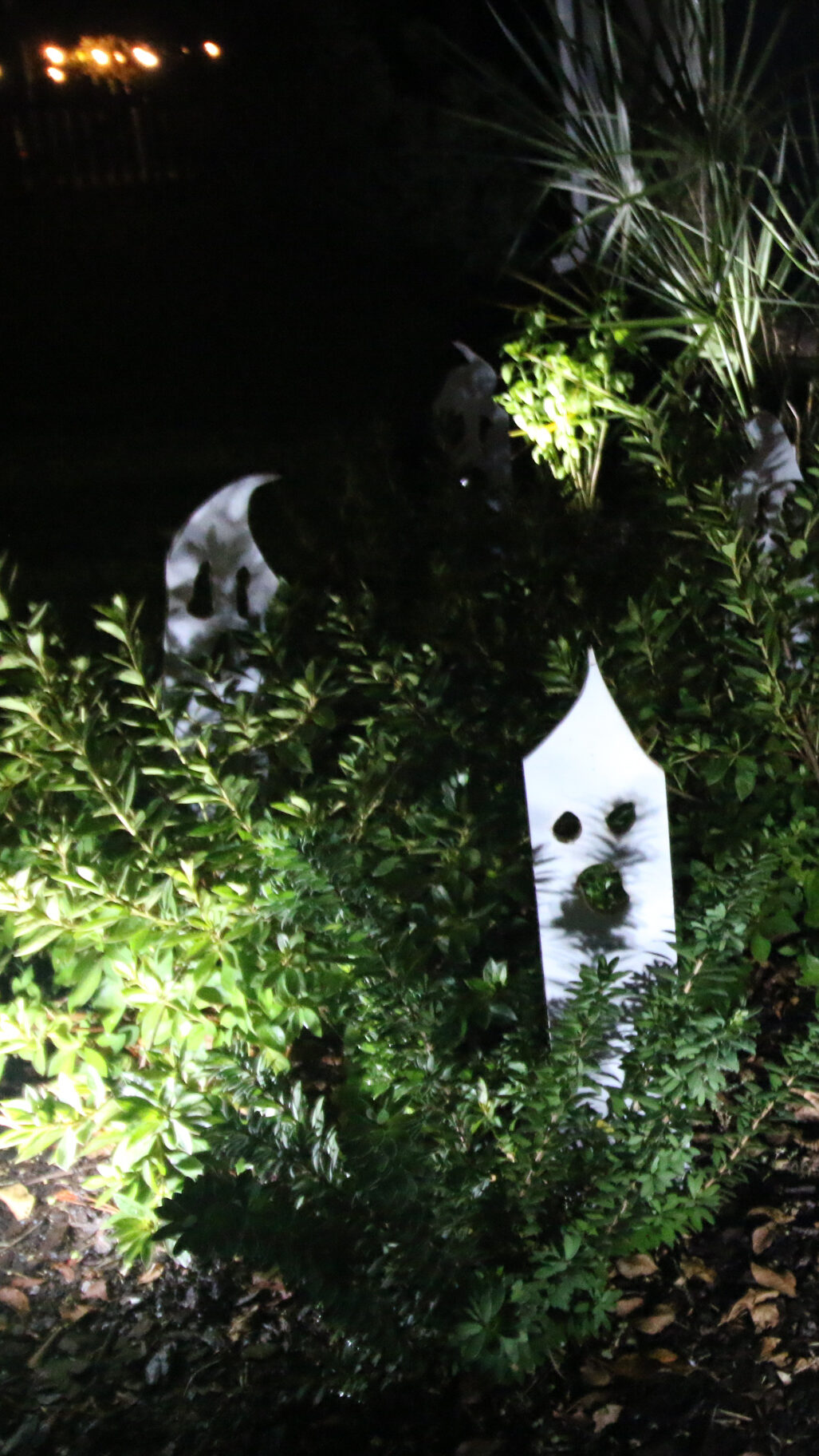 Wooden ghosts in bushes at night